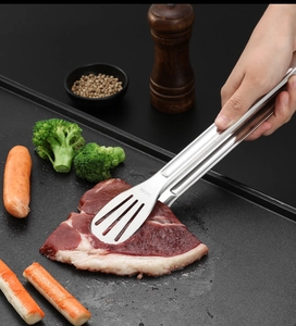 Nahaufnahme der Grillzange aus SUS304 Edelstahl beim Wenden eines Steaks auf dem Grill
