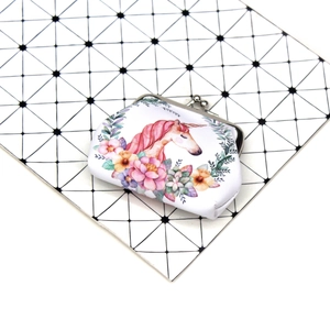 Detail of fabric unicorn coin purse with metal clasp on geometric pattern background