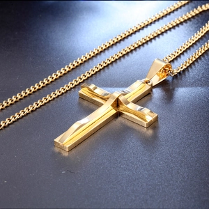 Detailed close-up of golden stainless steel cross pendant with high-shine polished finish