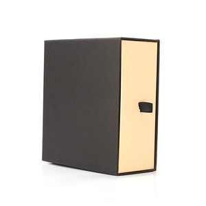 Pull-out cardboard belt box in black and beige with a black ribbon handle on white background