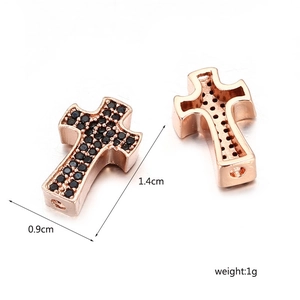 Makro-Detail eines 1,4 cm roségoldenen Kreuzanhängers mit schwarzen Zirkonia