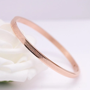 Close-up of rose gold stainless steel bangle with Greek meander pattern and hidden clasp