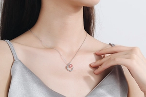 Close-up of a silver moon pendant necklace with pink strawberry quartz on a collarbone