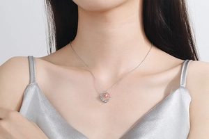 Close-up of strawberry quartz moon pendant on silver chain worn by a model