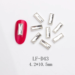 Detail of rectangular nail art rhinestone with silver beaded metal frame and red nail application