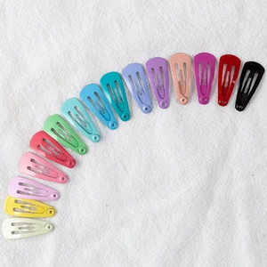 Detailed set of fifteen colorful 2cm mini dog hair clips on a white fabric surface