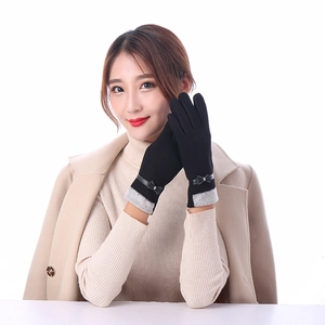Close-up of black winter gloves for women with grey knit cuffs and leather bow detail