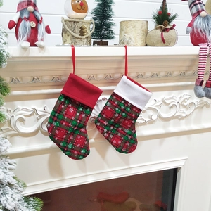 Set of 2 festive Christmas stockings with snowflake patterns hung on a holiday fireplace
