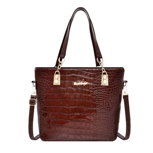 Deep brown crocodile embossed tote bag with gold hardware on a clean white background