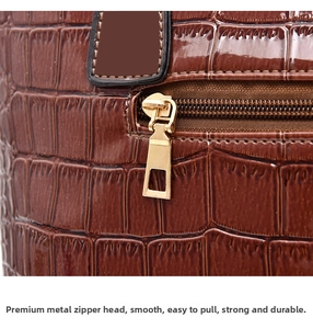 Macro shot of dark brown crocodile embossed leather bag with smooth golden metal zipper