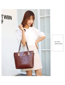 Fashionable dark brown crocodile pattern tote bag shown with model in casual white outfit
