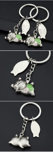 Detail of silver cat keychain with fishbone charm showing front side and back views