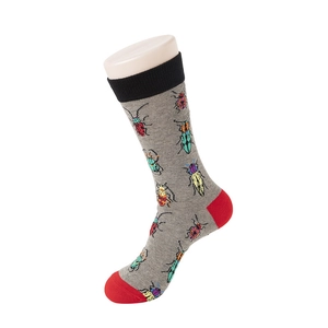 Detail of grey crew socks with beetle patterns, featuring black cuffs and red heels