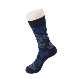 Detail view of navy blue crew socks with blue leaf patterns on knitted combed cotton