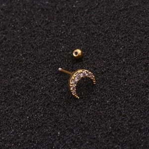 Minimalist gold moon stud earring with zircons and ball back on black foam background