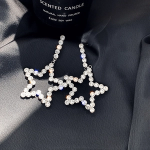 Elegant star tassel drop earrings with sparkling rhinestones on black silk background