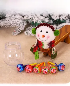 Detail view of snowman Christmas candy jar with red green scarf and earmuffs decor