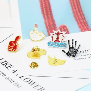 Detail of creative enamel pins with rock gestures and colorful heart hand designs