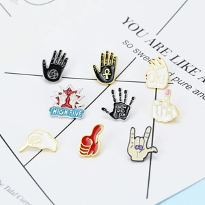 Detailed close-up of cartoon enamel hand gesture brooches including rock and peace signs