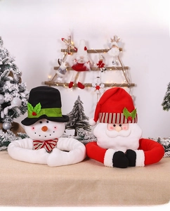 Detail of plush Santa and Snowman curtain tiebacks on a decorated Christmas tree