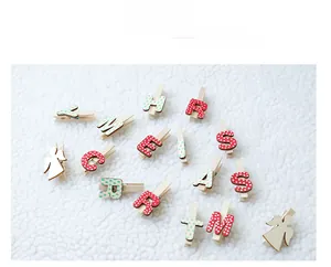 Détail de pinces de Noël en bois avec anges et lettres sur fond de fourrure blanche