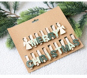 Détail de pinces de Noël en bois avec anges et lettres Merry Christmas sur carton