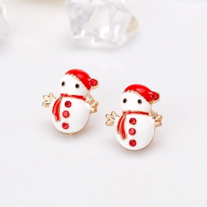Macro detail of white snowman stud earrings with vibrant red rhinestones and oil drop finish