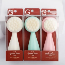 Three facial cleansing brushes in white, mint green, and pink with plastic packaging
