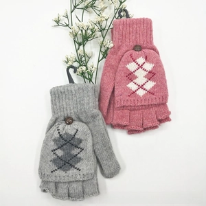 Détail de mitaines en tricot avec motif flocon de neige et bouton en bois naturel