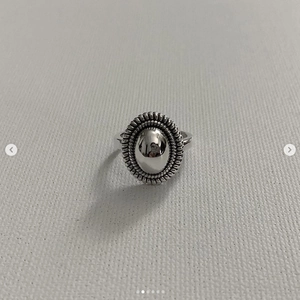 Top view of a vintage 925 sterling silver ring with oval mirror surface and embossed edges