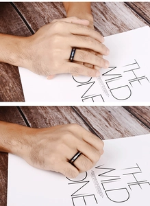 Close-up of dual-tone black and silver stainless steel ring with diamond accents