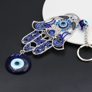 Detail of Hamsa Hand keychain featuring blue evil eye charms and sparkling blue rhinestones