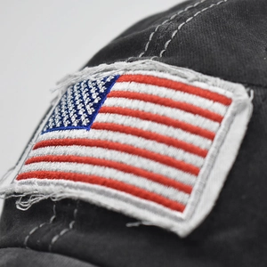 Detail shot of American flag embroidery on black washed cotton baseball cap texture