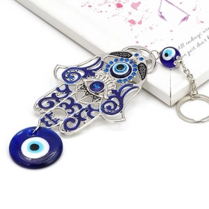 Detailed view of silver Hamsa Hand and blue Evil Eye keychain with sparkling crystals
