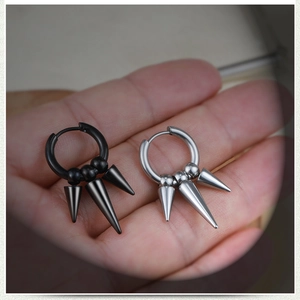 Close-up of black and silver stainless steel hoop earrings with long cone spikes