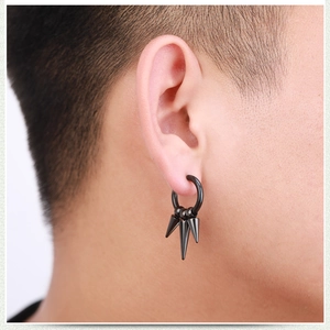Close-up of black stainless steel punk hoop earrings with triple cone spikes on male ear