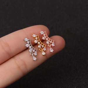 Pentagram zircon earrings in silver, gold, and rose gold finishes on dark background