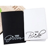 Close-up of black Groom and white Bride faux leather passport covers for couples