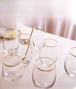 Macro detail of transparent glass cups with gold rims and stainless steel spoons