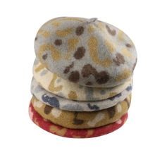 Dettaglio di cappelli baschi in lana con stampa leopardata impilati per donna in inverno