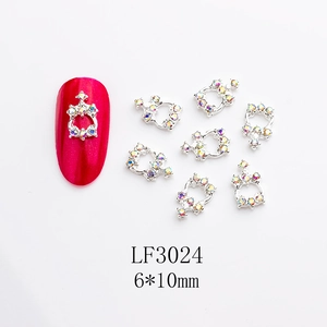 Close-up of crown alloy nail art charms with AB rhinestones on a red nail, 6x10mm size