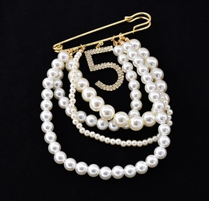 Elegant gold safety pin brooch with layered pearls and sparkling crystal number 5 pendant