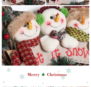 Detail of Christmas wreath with three plush snowmen and a decorative Let it snow wooden sign