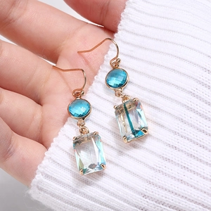 Macro shot of long geometric earrings with aqua blue and iridescent k9 crystal glass