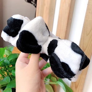 Detail of plush cow print headband with soft texture and cute bow tie for skin care