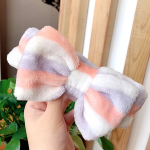 Detail of pink and white striped plush bow headband made of soft coral fleece material