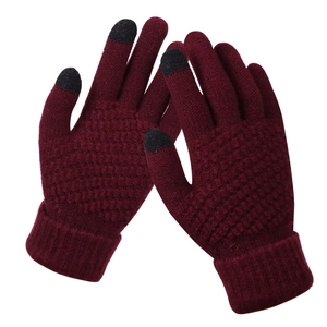 Detail of dark red knit gloves with black conductive touchscreen tips for winter use