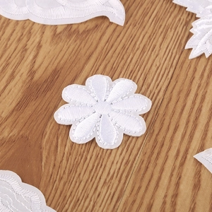 Detailed white rose embroidery patch for clothing repair on a natural wood background