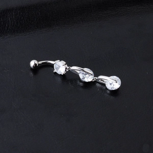 Macro shot of silver navel piercing ring with clear zircons on black background