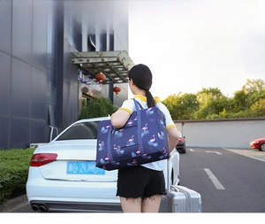 Waterproof travel bag with pink flamingo print shown mounted on a suitcase handle